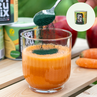 Spirulix Powder Teelöffel über Glas Karottensaft